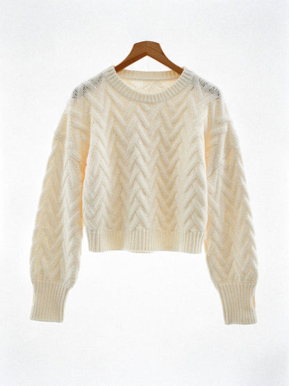 Cropped cable knit jumper in Shortbread cream on a wooden hanger, front view