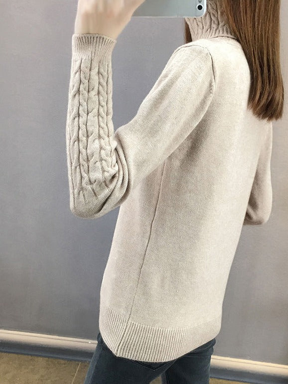 Back of the cable knit roll neck jumper in Fawn showing the sleeve cable and ribbed hem