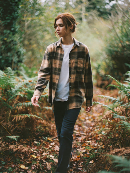 Woman wearing a camel check flannel overshirt in autumn woodland