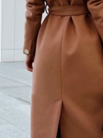 Turn back cuff with its single button and the belt tied at the back of the camel wrap coat