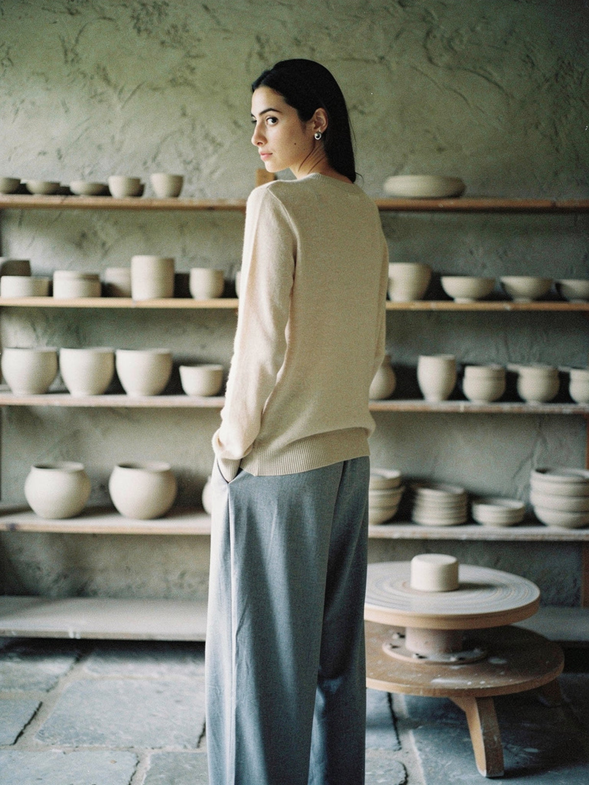 The Avington camel jumper in Calico worn with grey trousers