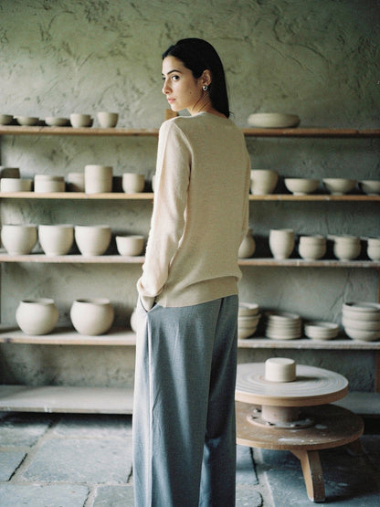 The Avington camel jumper in Calico worn with grey trousers