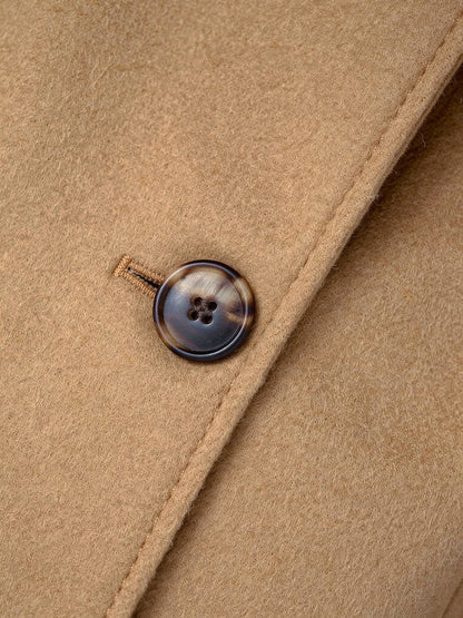 Close up of the brushed coating and horn finish button on the camel overcoat