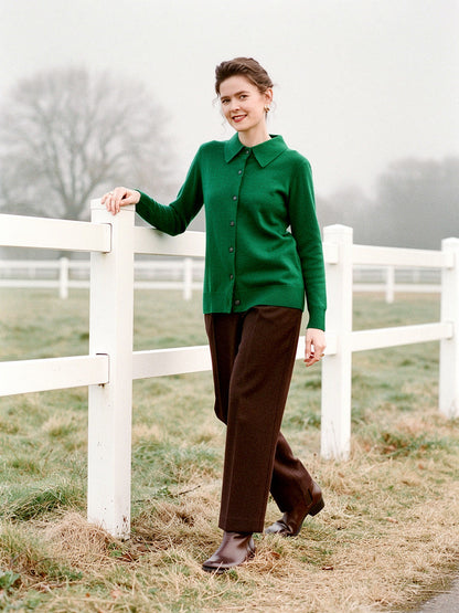 Womens cashmere cardigan in Racing Green worn buttoned beside white paddock fencing