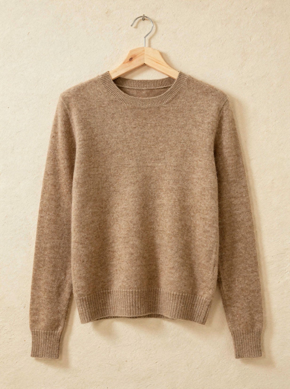 Camel cashmere crew-neck jumper on a wooden hanger