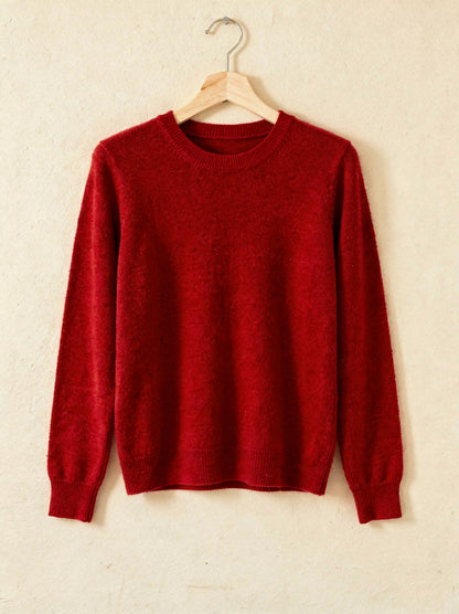Ruby red cashmere crew-neck jumper on a wooden hanger