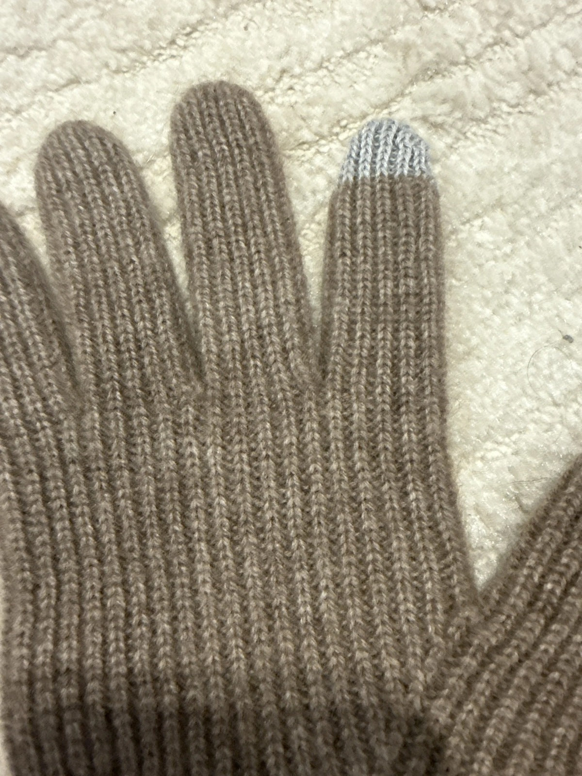 The rib knit and touchscreen tip of the Partridge cashmere gloves seen in daylight