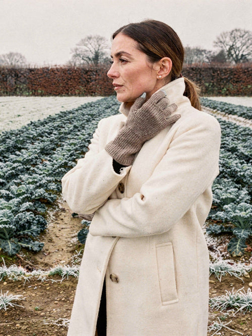 Woman wearing the Partridge cashmere gloves, the long ribbed cuff drawn up over her coat sleeve