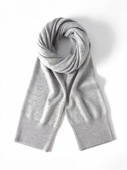 Oyster cashmere scarf laid flat and coiled on a white background