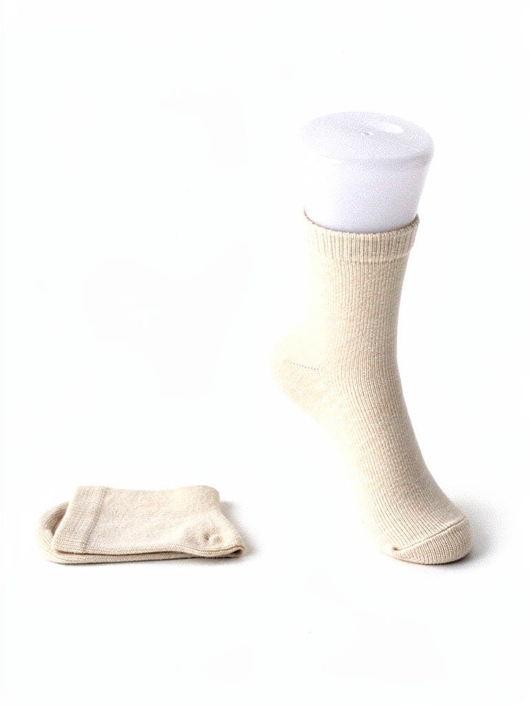 Cashmere socks in Oatmeal, the undyed pale shade, shown as a pair