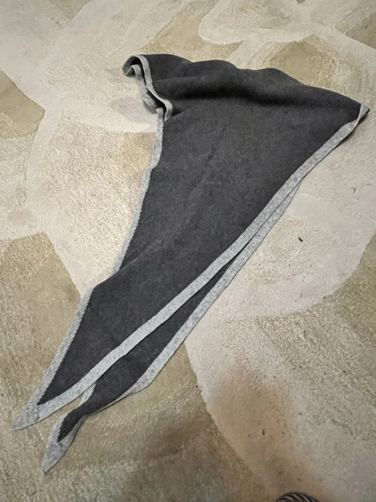 Cashmere triangle scarf in Cobblestone laid flat to show the triangle and its tapering ends