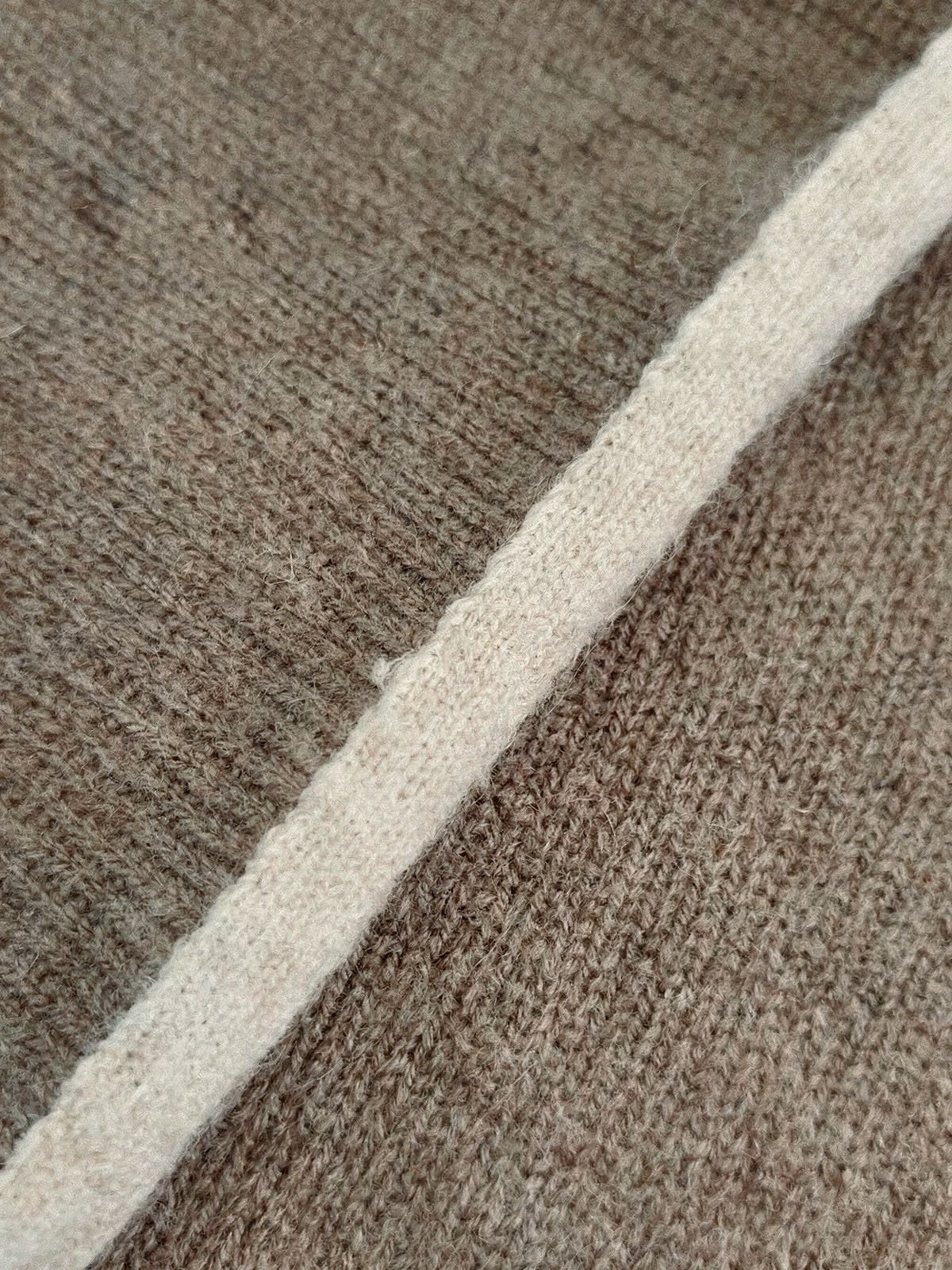 Close up of the fine rib knit and the knitted contrast edge of the cashmere triangle scarf