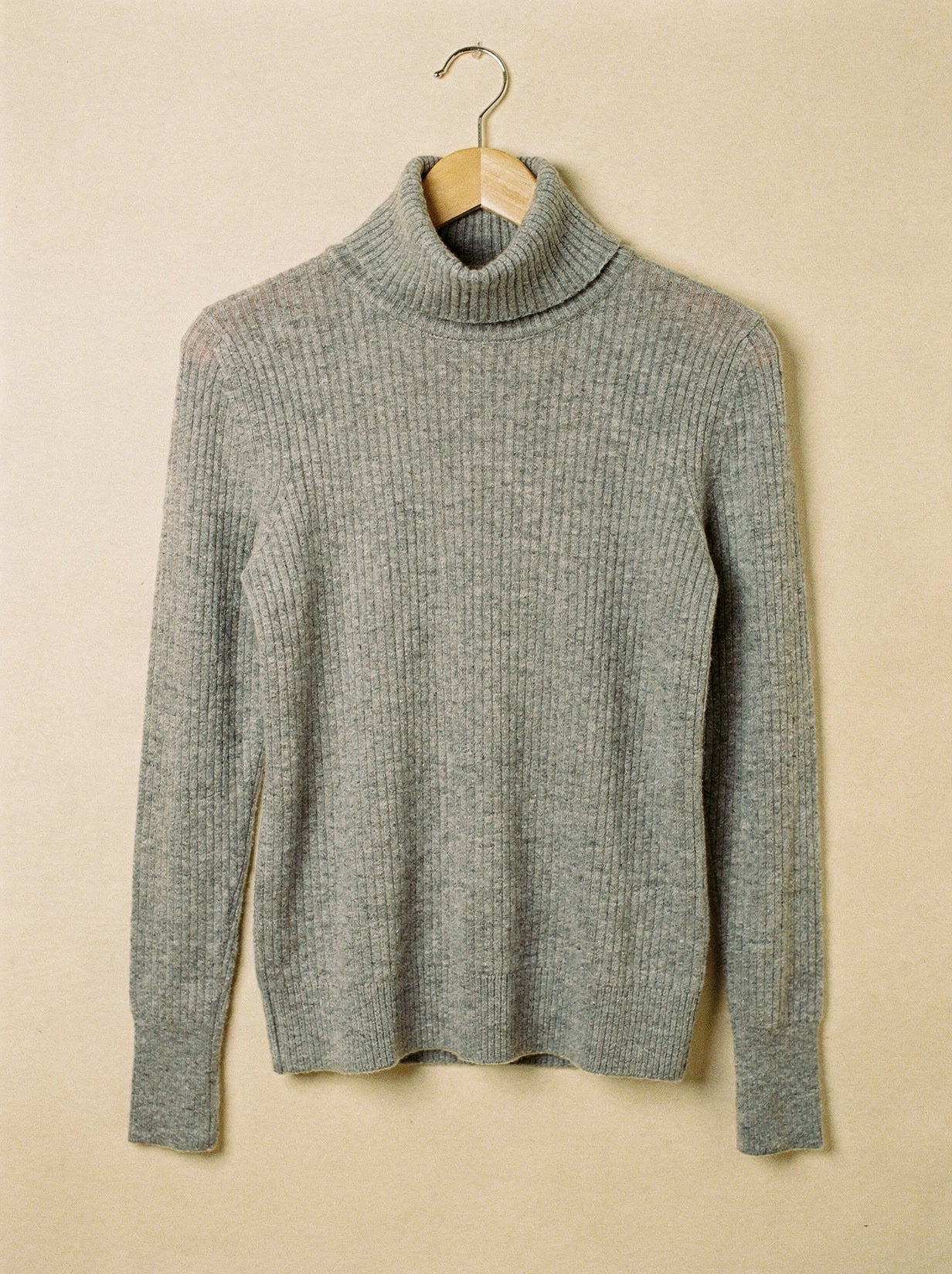 Flannel grey cashmere turtleneck jumper on a wooden hanger