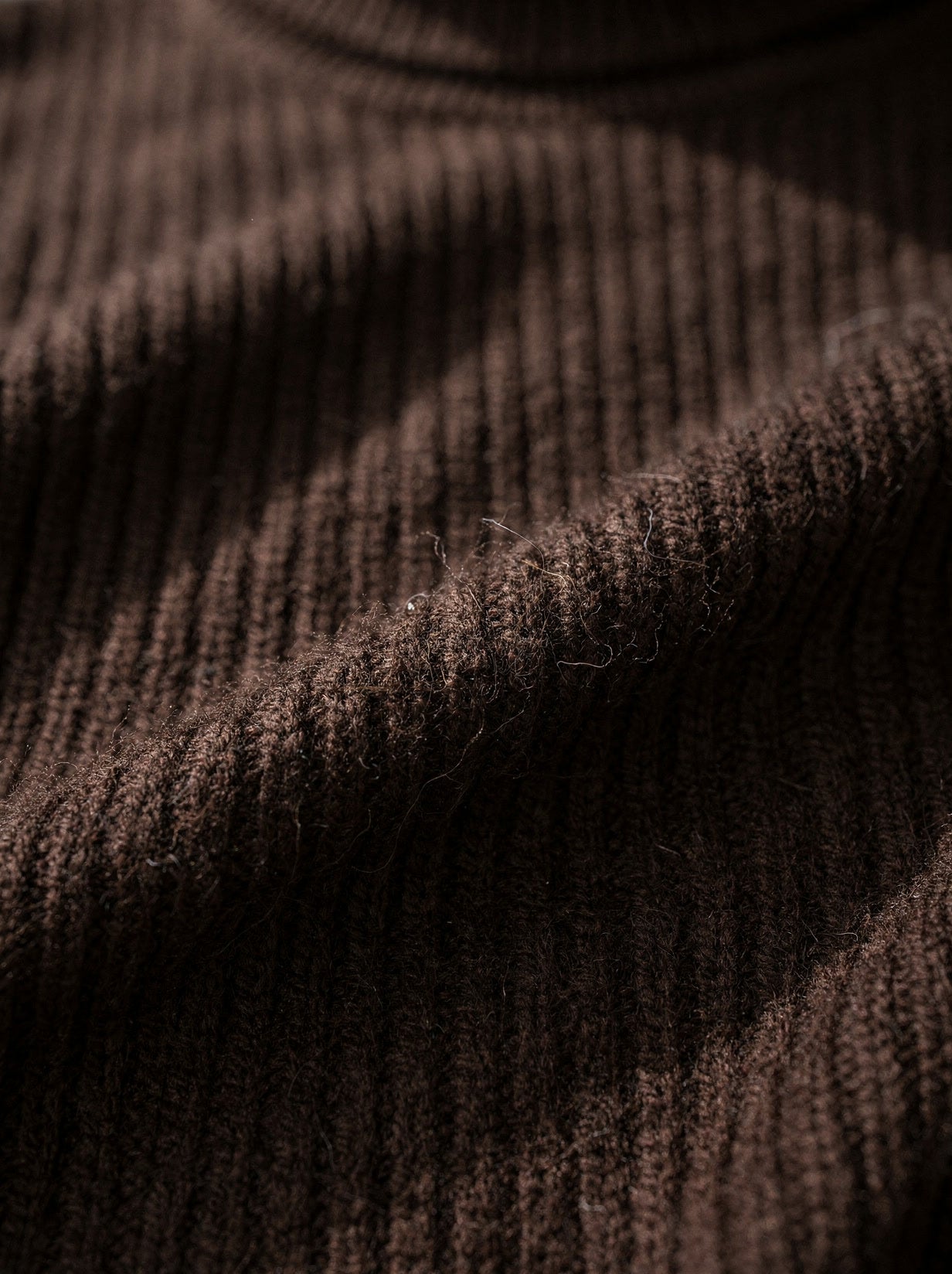 Close-up of the fine ribbed cashmere knit and folded roll neck