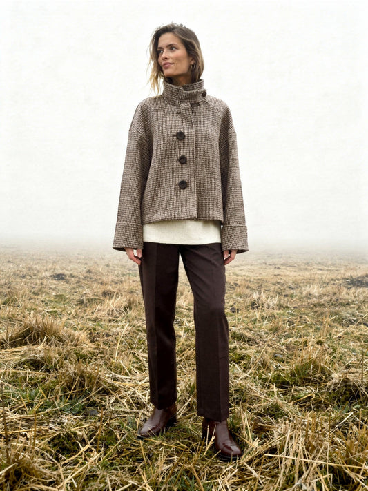 Womens check jacket in Russet houndstooth, worn buttoned in a misty winter field with the tall funnel collar standing up