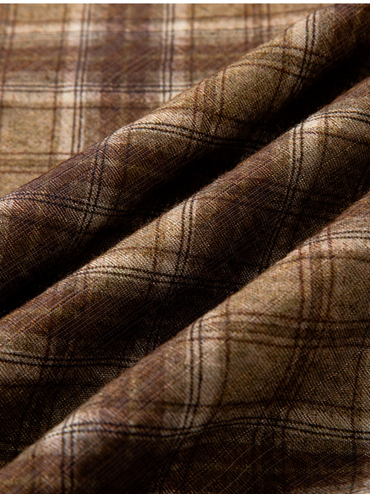 Close-up of the checked pleated skirt cloth, a soft camel and chocolate check on a fine flat weave