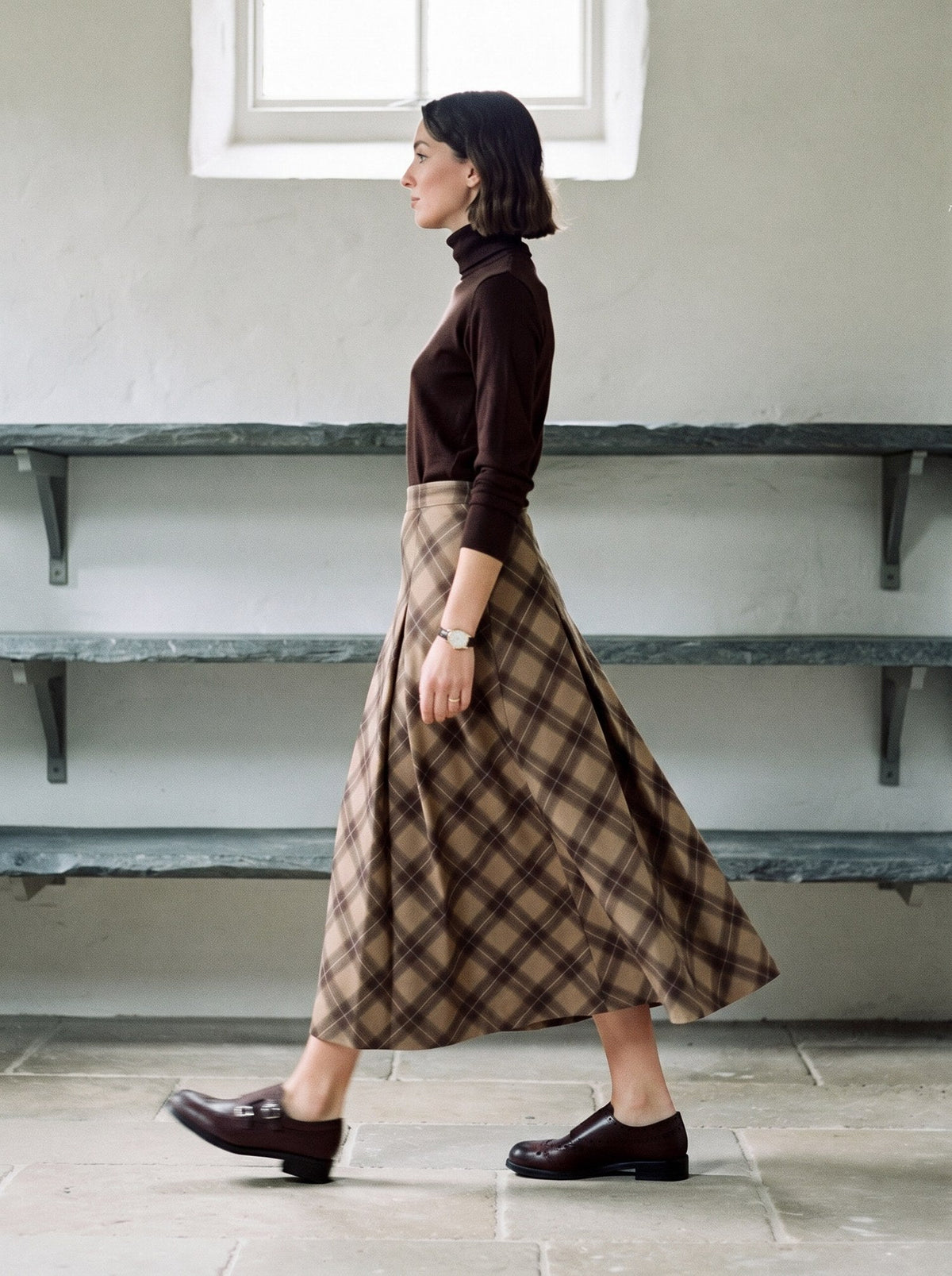 Checked pleated skirt worn walking, showing the swing of the bias-cut check