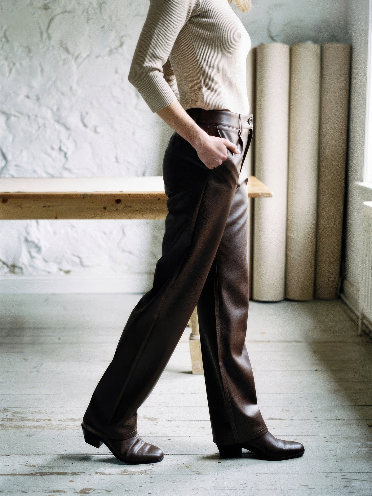 Coffee faux leather trousers worn in profile, full length