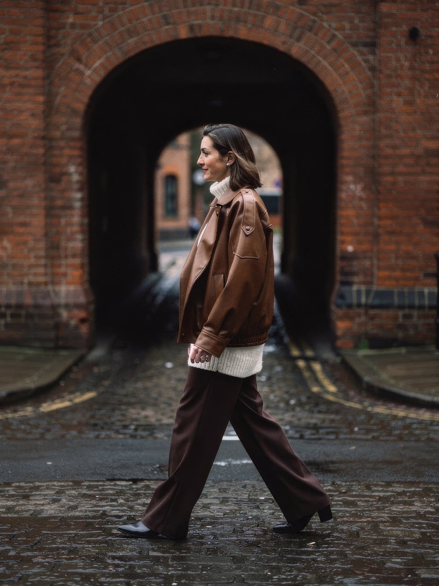 Cognac faux leather jacket worn open over a cream jumper