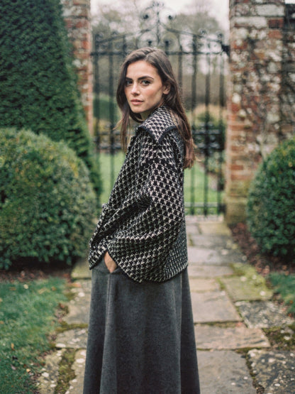 Black ecru collared cardigan in two-tone textured knit, worn in an English garden