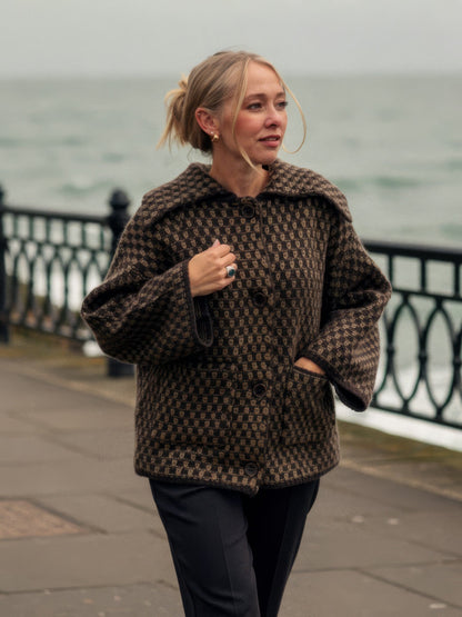 Womens collared cardigan in cocoa brown chunky two-tone knit, worn buttoned on a quiet seaside esplanade | Ledbury