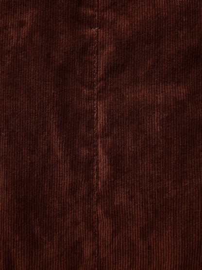 Close-up of the corduroy on the Amarone burgundy skirt, the ribs running straight down the cloth either side of a topstitched seam