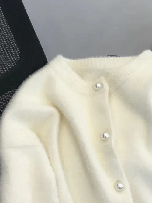 Ribbed round neckband and pearl buttons of the cream fluffy cardigan