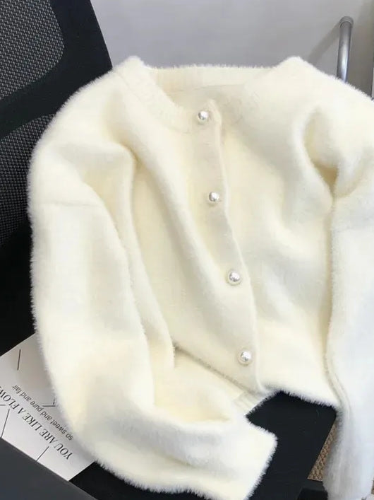 Cream fluffy cardigan laid flat, front view with pearl button placket