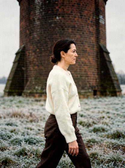 Side view of the cream fluffy cardigan showing its cropped length at the waist