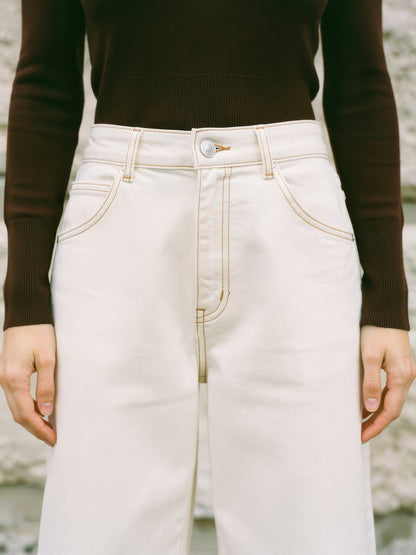 High waistband of the cream jeans with belt loops, one button, zip fly and curved front pockets
