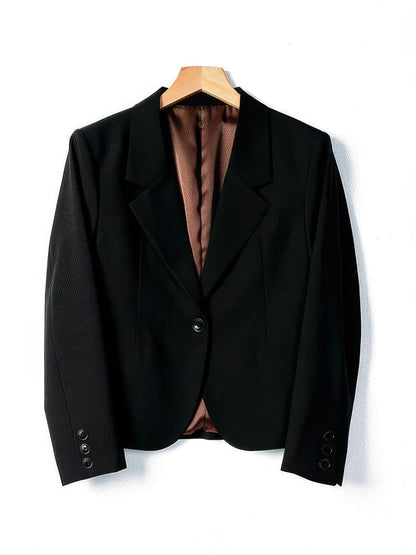 Cropped blazer in Black on a wooden hanger, front view