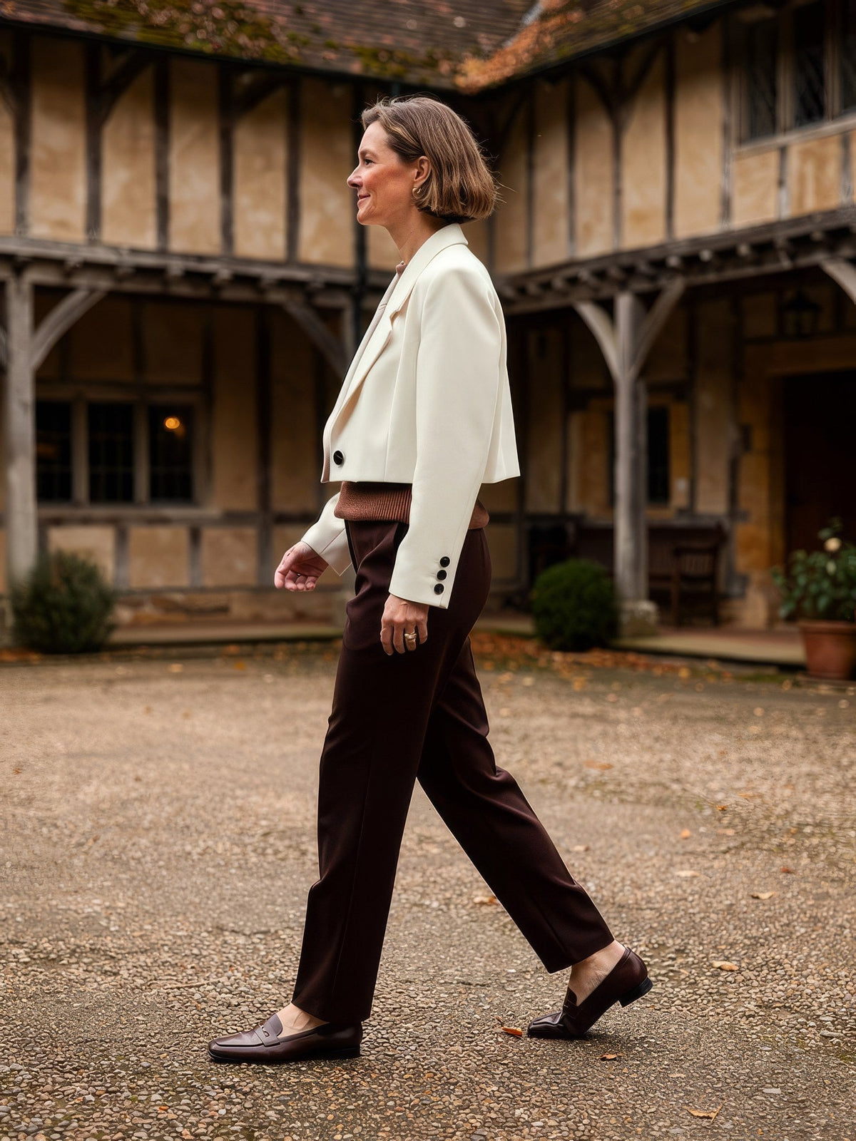 Womens cropped blazer in Bone ivory worn in a galleried courtyard, side view