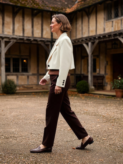 Womens cropped blazer in Bone ivory worn in a galleried courtyard, side view