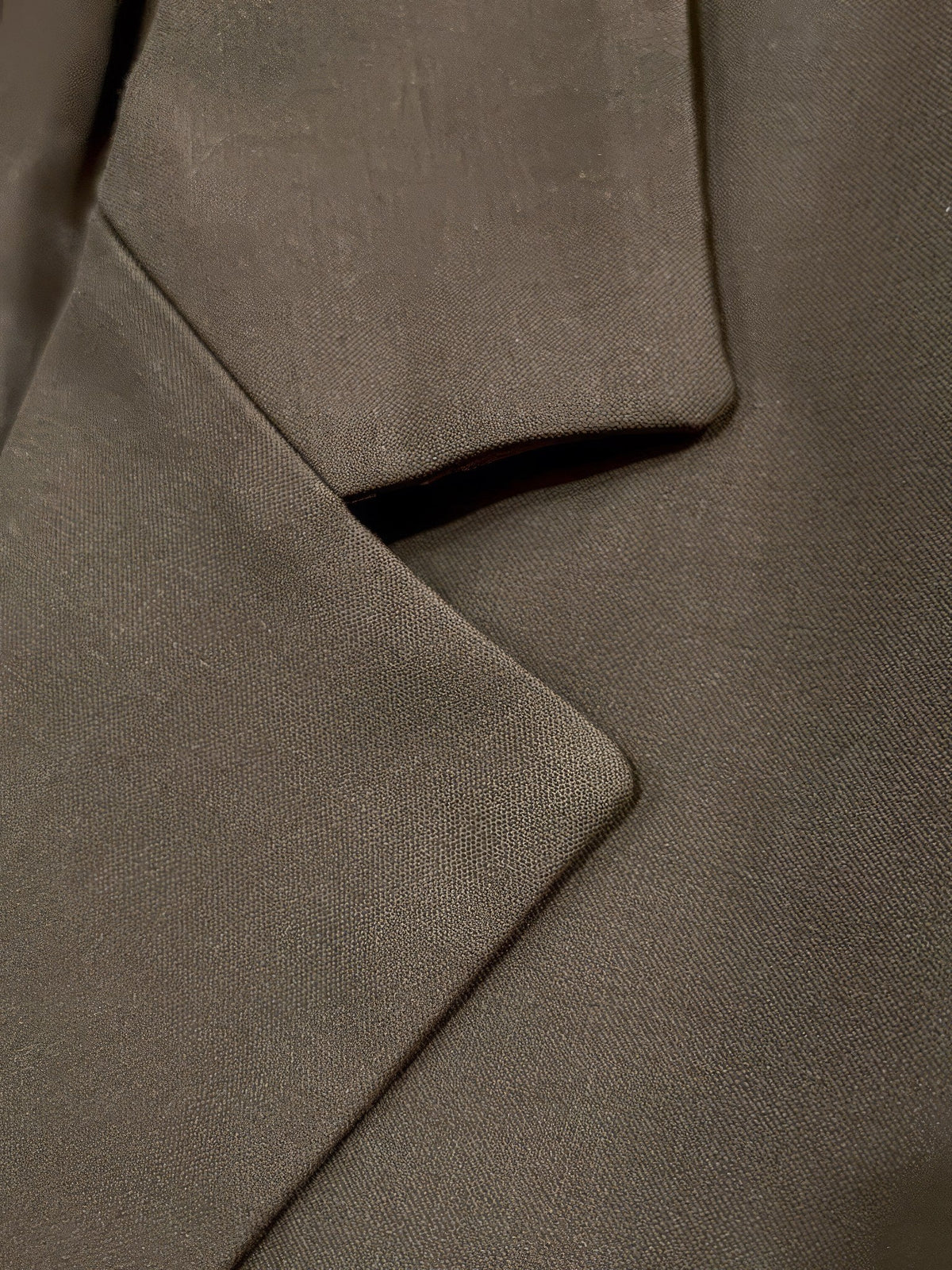Close up of the notch lapel and matte woven fabric of the cropped blazer