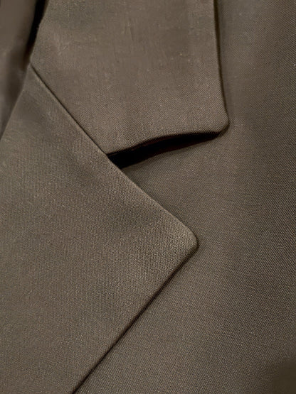 Close up of the notch lapel and matte woven fabric of the cropped blazer
