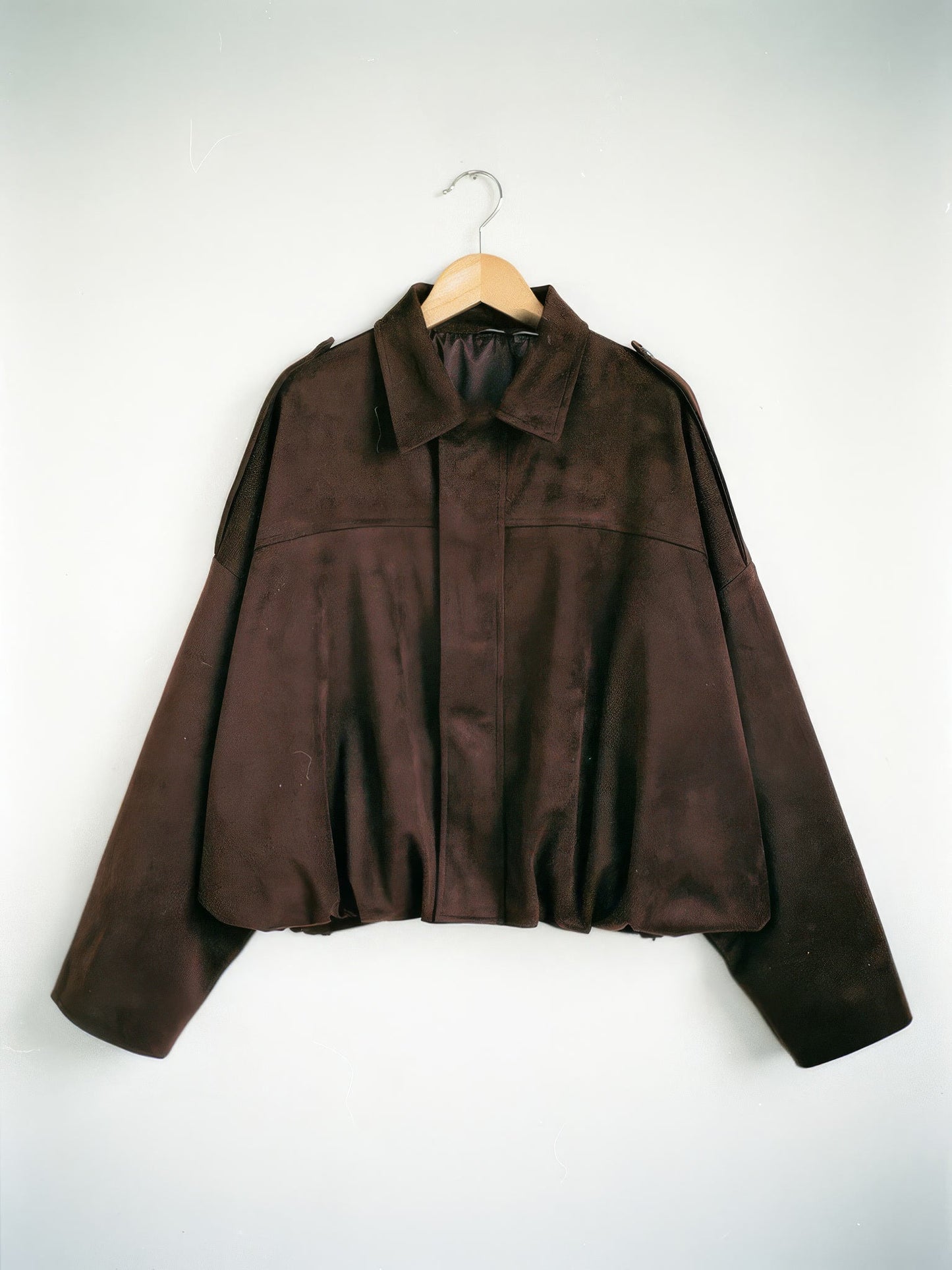 Chocolate brown cropped faux-suede jacket with batwing sleeves on a wooden hanger