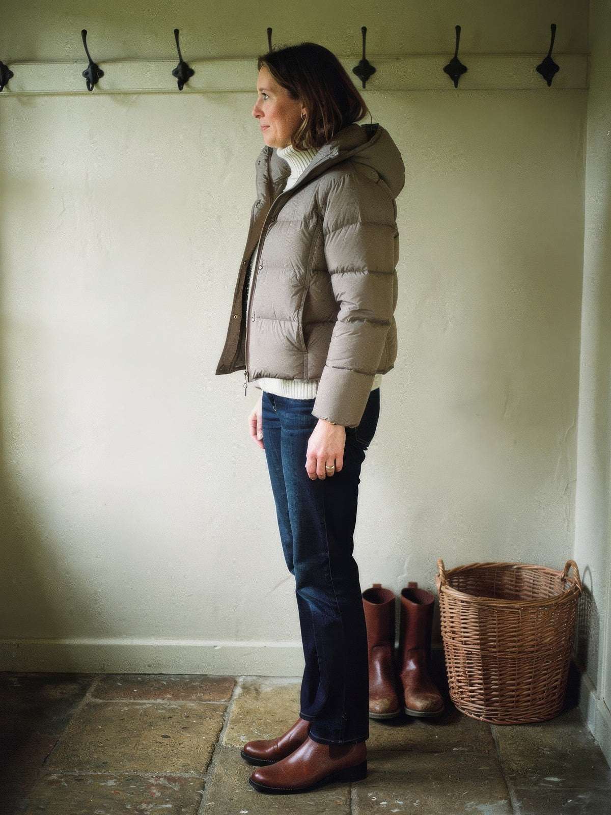 Womens cropped puffer jacket in Mushroom worn in a country house boot room, side profile