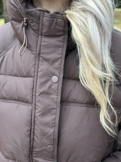 Close up of the press stud placket and hood drawcord on the cropped puffer jacket