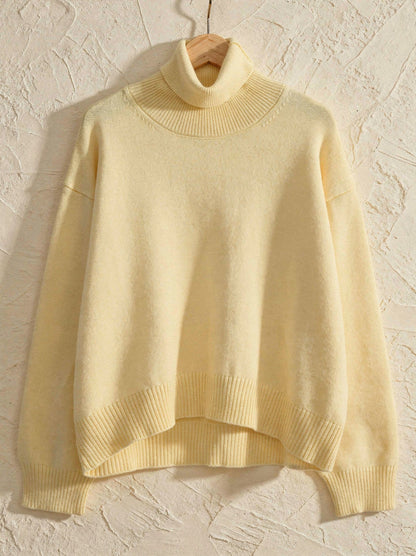 Butter yellow cropped turtleneck jumper on a wooden hanger