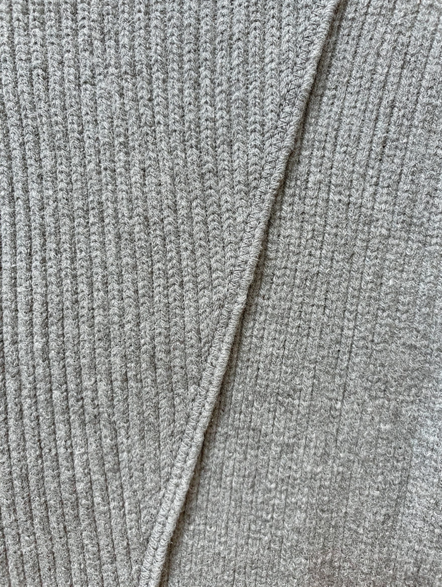 Close-up of the grey marl rib knit and crossover seam of the jumper dress