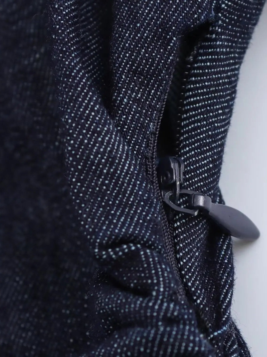 Side seam zip and gathered waist of the denim dress