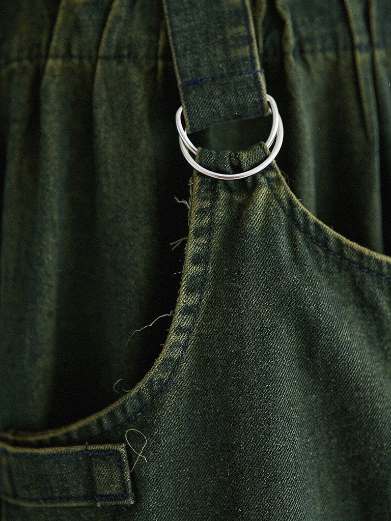 Close-up of the denim pinafore dress strap ring, gathered bib and washed twill