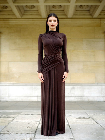 Draped maxi dress in Bourbon worn in a stone loggia, three-quarter front view, floor length