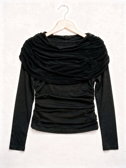 Black draped top on a hanger, showing the wide pleated shawl collar and the ruched body