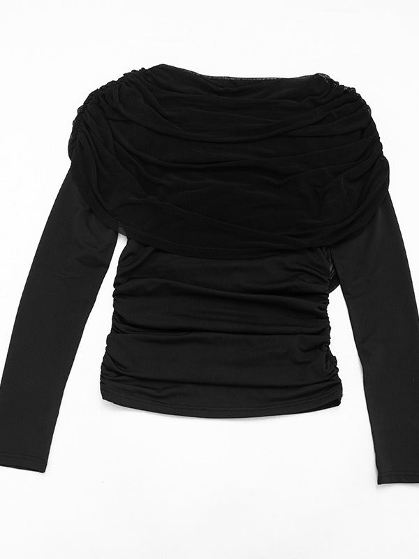 The black draped top laid flat, showing the shawl collar, ruched body and long sleeves