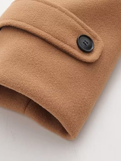 Buttoned cuff tab on the sleeve of a camel duffle coat