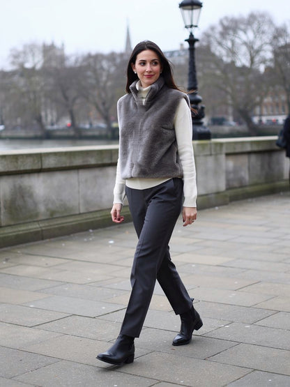 Womens faux fur gilet in Ash Grey, cropped funnel neck, worn on a London river embankment