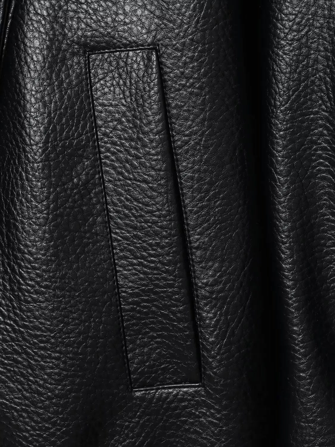 Grained faux leather texture and welt pocket close-up