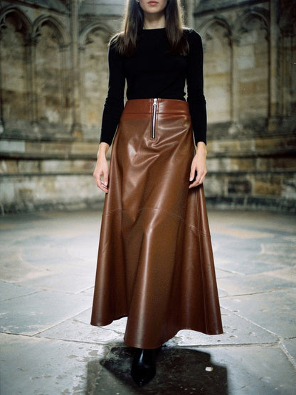 Womens faux leather maxi skirt in saddle brown with an exposed front zip, worn in a cathedral chapter house