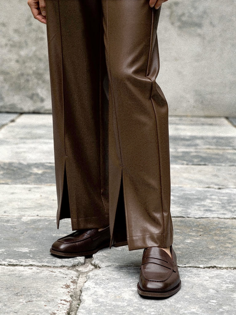 Split hem detail of the floor length faux leather trousers